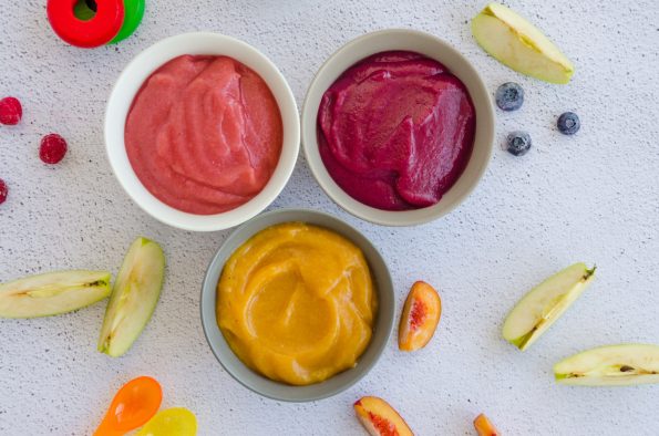 Baby food. Homemade fruit puree. Variety of apple puree with peach, raspberries and blueberries