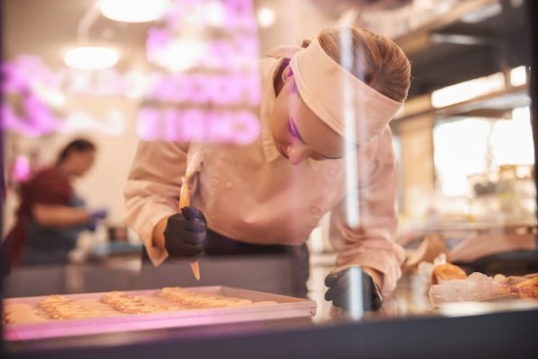 Inspired pastry chef making macarons in stylish modern kitchen space