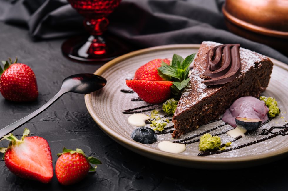 Brownie cake with a scoop of vanilla ice cream and strawberries