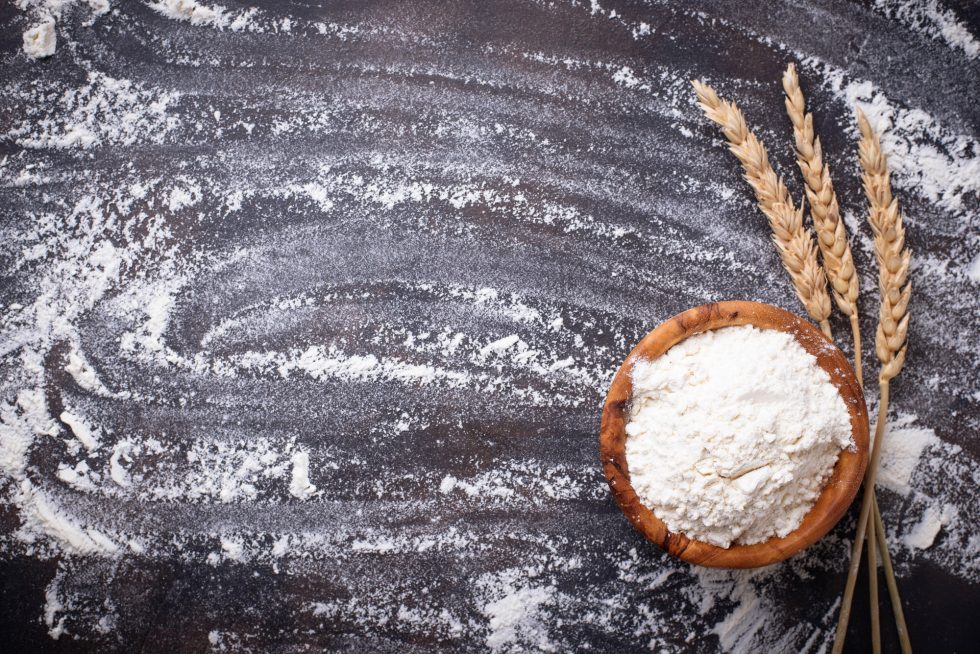 Wheat flour in bowl and ears